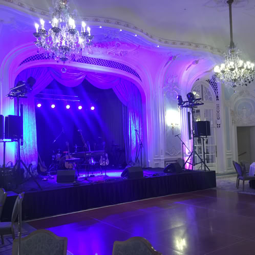 Elderly African American percussionist energetically playing conga drum outdoors.